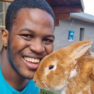 Photo d'un jeune homme cajolant un lapin